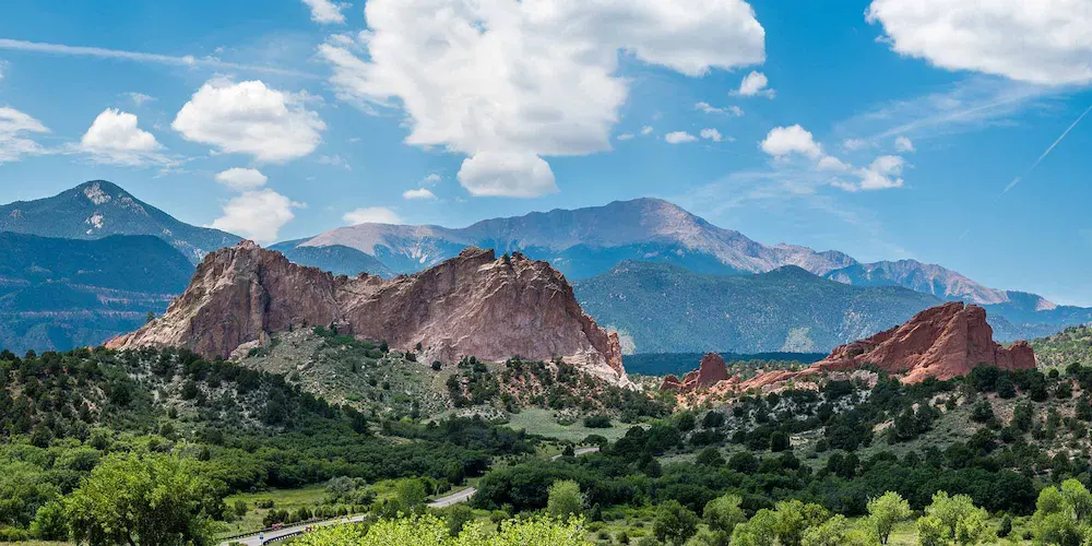 Scenic view of the Garden of the Gods in Colorado, showcasing stunning red rock formations against a clear blue sky.