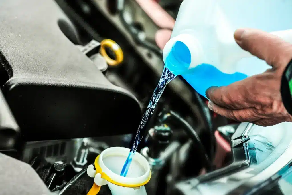 A person pouring wiper fluid