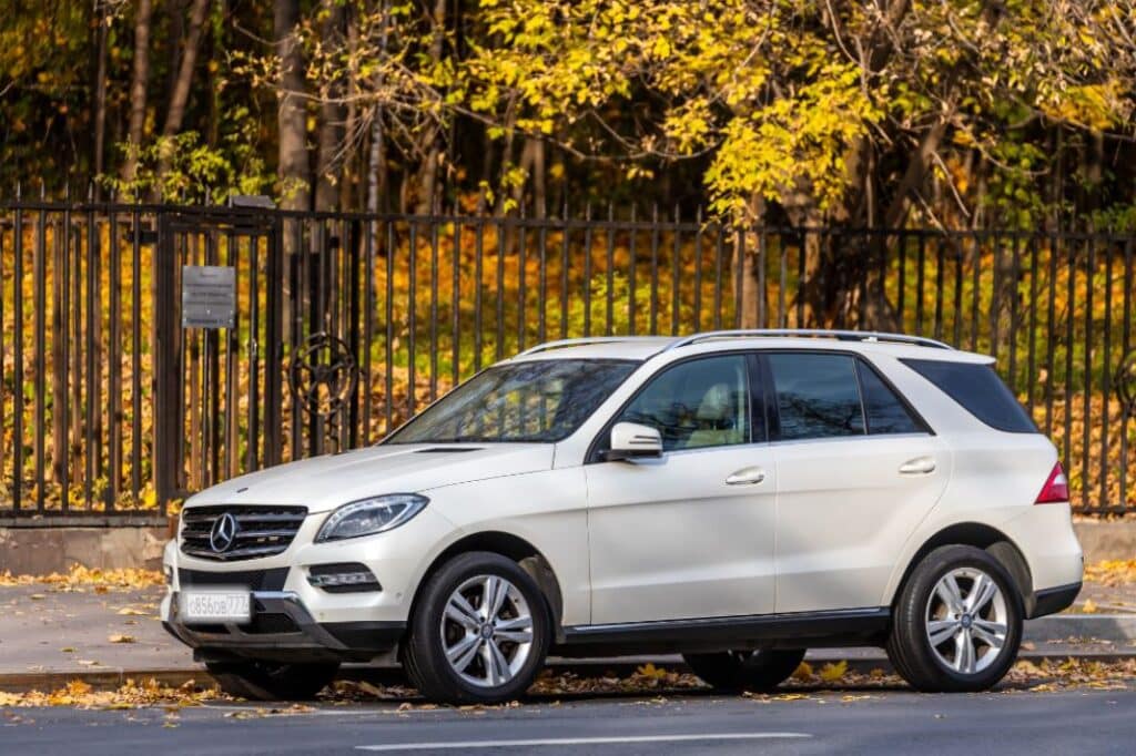 Can I take my Mercedes for service at a local auto repair shop in Colorado Springs, CO with Express Auto Repair on Montebello. Image of white Mercedes SUV parked on the side of road with black iron gate around grounds with fall trees and leaves in the background.