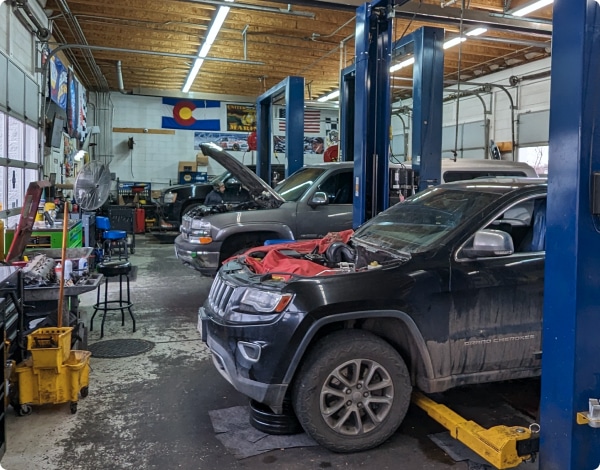 Carmax Maxcare, Auto Repair in Colorado Springs, CO at Express Auto Repair. Auto repair shop with two parked cars with open hood