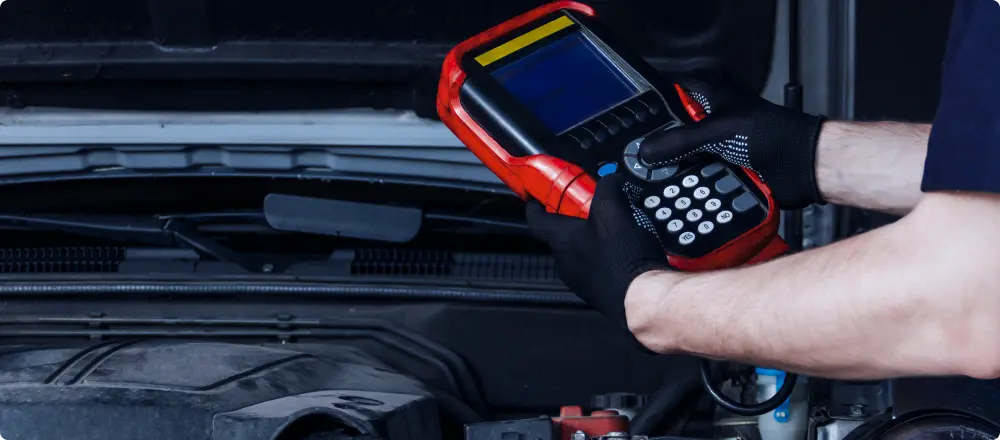 Engine Diagnostics, Auto Repair in Colorado Springs, CO at Express Auto Repair. a mechanic holding engine diagnostics equipment