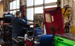 a mechanic inside an auto repair shop looking for tools