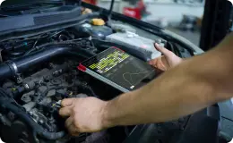 a mechanic performing engine diagnostics on the car hood