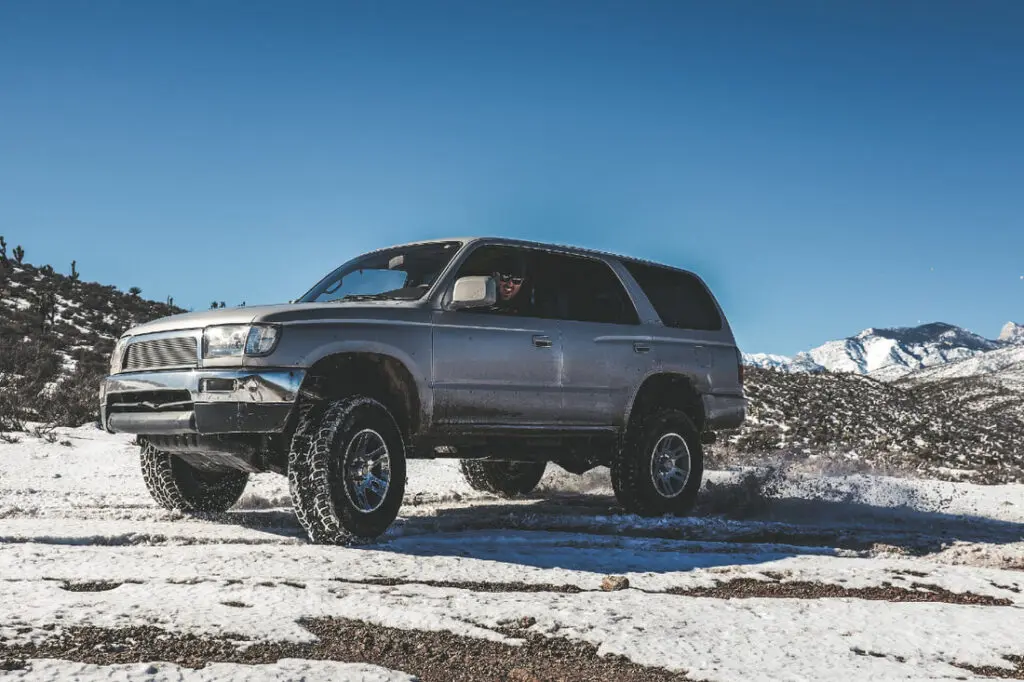 An SUV navigating a snowy road, showcasing its capability in winter driving conditions.