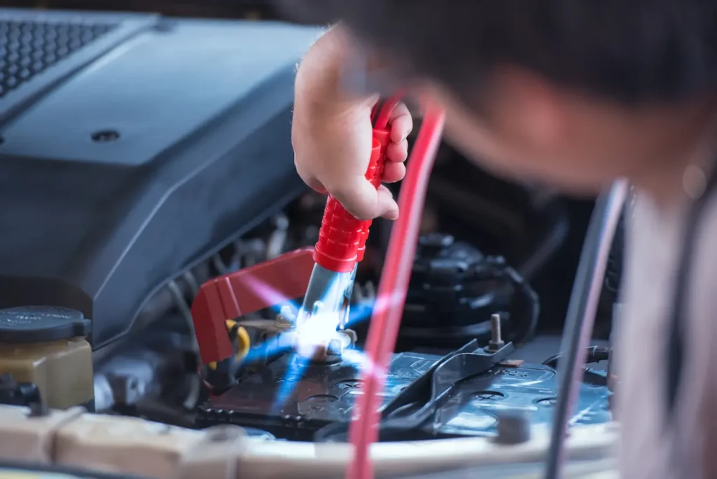 A person jumpstarting a car battery