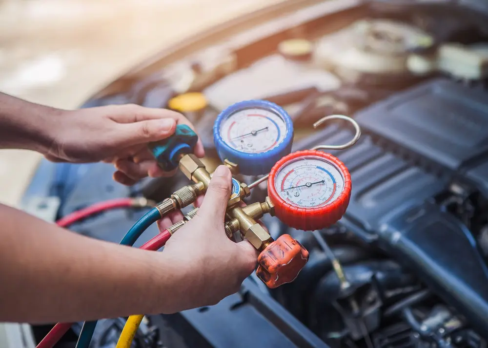 A person inspects a car engine using a gauge to check performance or diagnose issues.