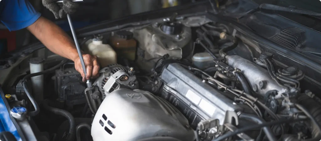 A technician replacing a vehicle's alternator