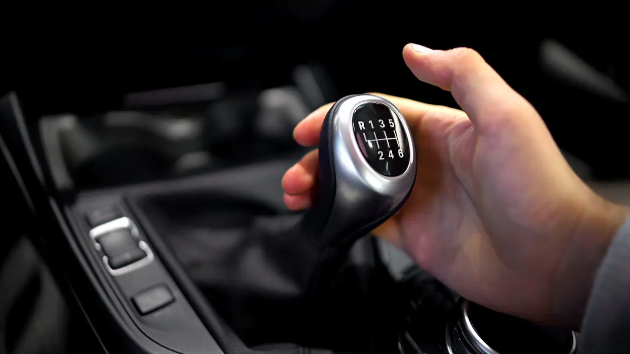 Close-up of a hand gripping the gear shift of a car