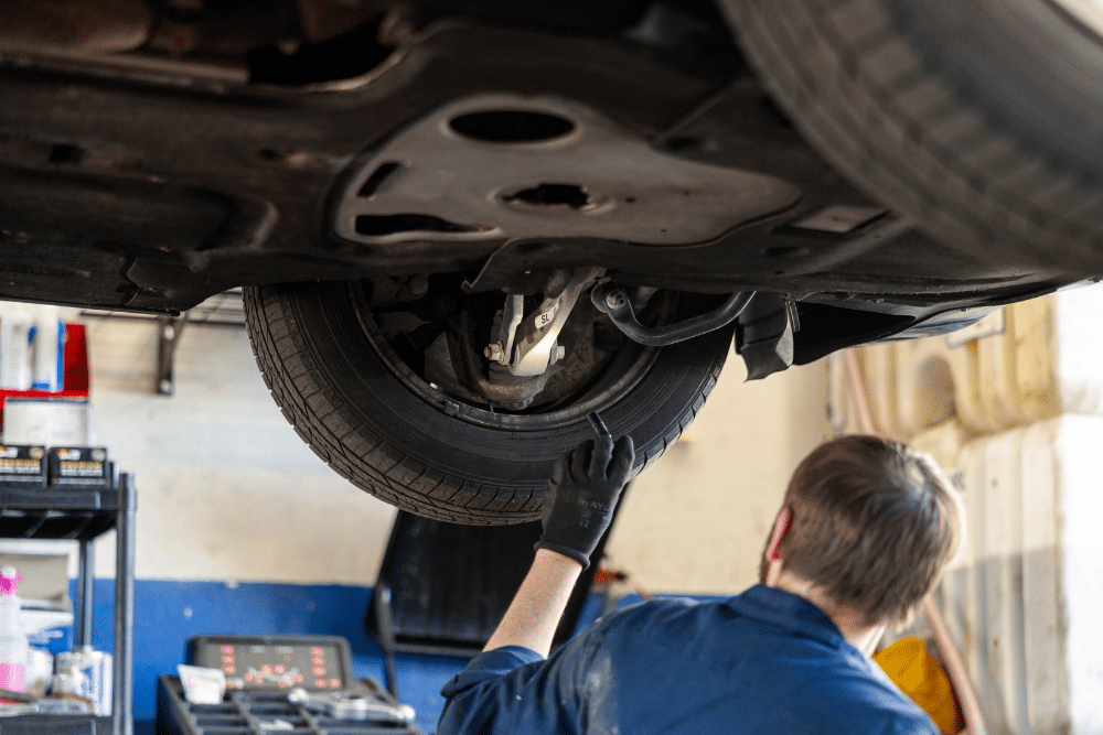 Winter Tire Swap, Tire Services in Colorado Springs CO At Express Auto Repair. Close-up of a lifted vehicle tire during inspection by an auto mechanic in a repair shop