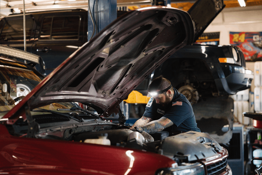 Tune up, auto repair in Colorado Springs, CO at Express Auto Repair. Image of technician performing engine tune-up and diagnostics under the hood, helping improve vehicle performance, fuel efficiency, and long-term reliability.
