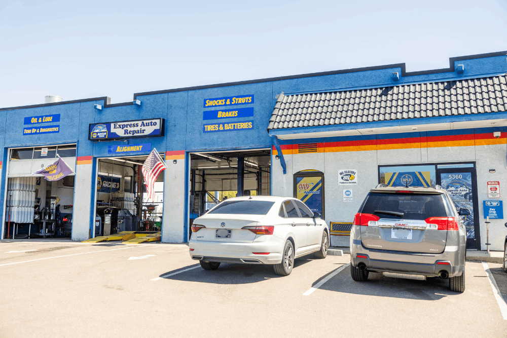 Vehicle safety check, auto repair in Colorado Springs, CO at Express Auto Repair. Image of the shop exterior with open service bays and vehicles parked outside for automotive care.