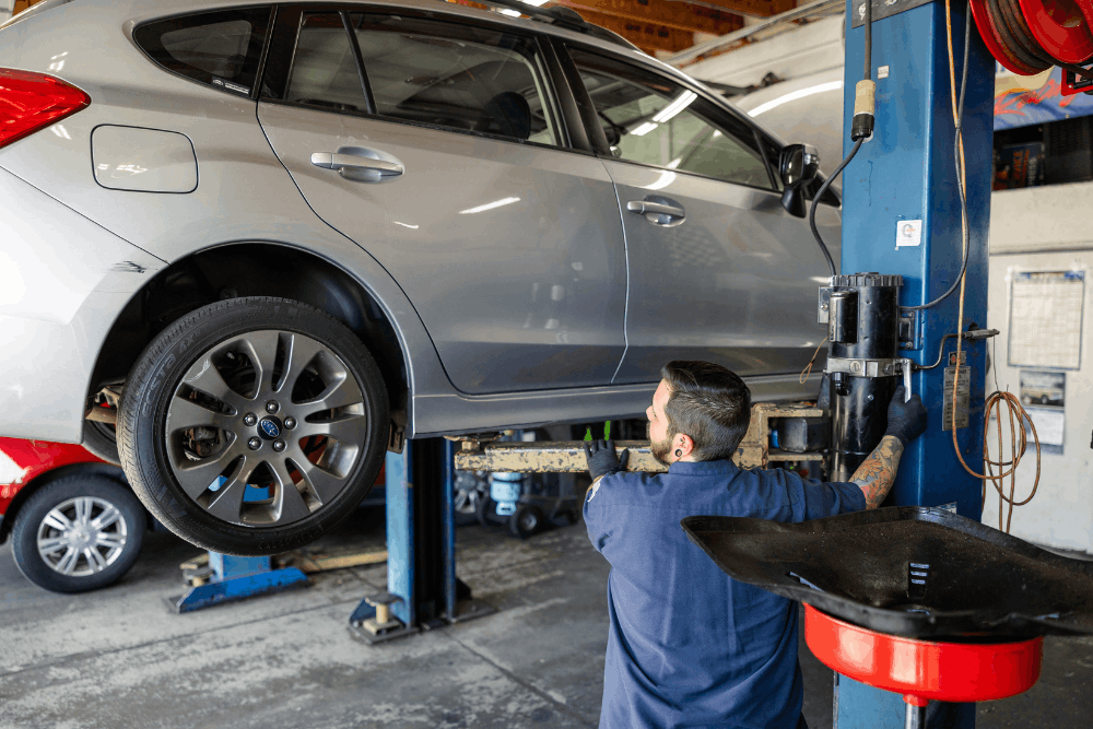 Subaru AWD, auto repair in Colorado Springs, CO at Express Auto Repair. Image of a technician working beneath a Subaru raised on a lift to support reliable all-wheel-drive performance and maintenance.