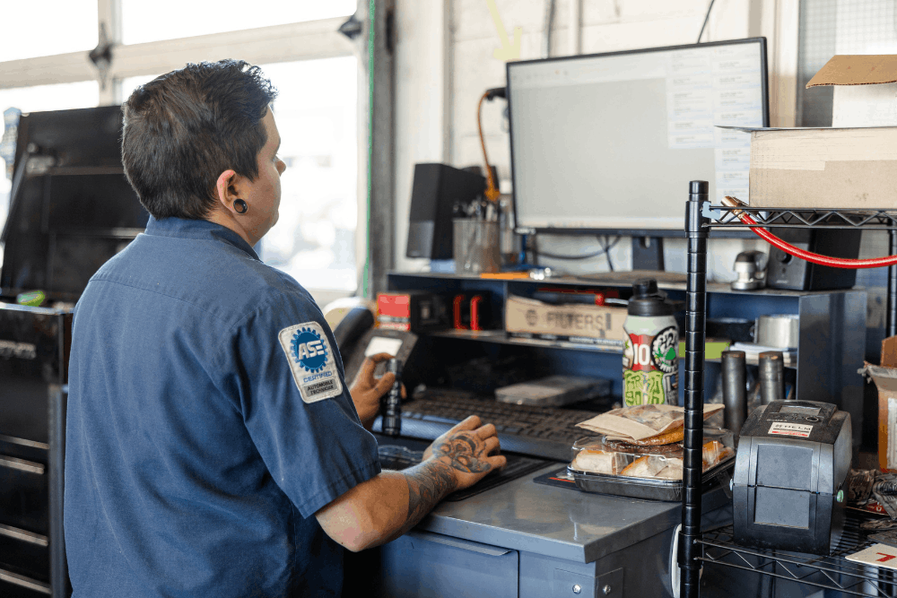 Car repair estimate, auto repair in Colorado Springs, CO at Express Auto Repair. Image of a technician reviewing service information on a computer at a repair shop workstation to support accurate vehicle service planning.